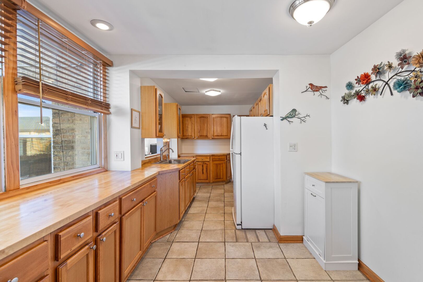 5300 West Foster Avenue Chicago, IL 60630 - Photo 10 of 27 a large white kitchen with a sink a refrigerator and a window