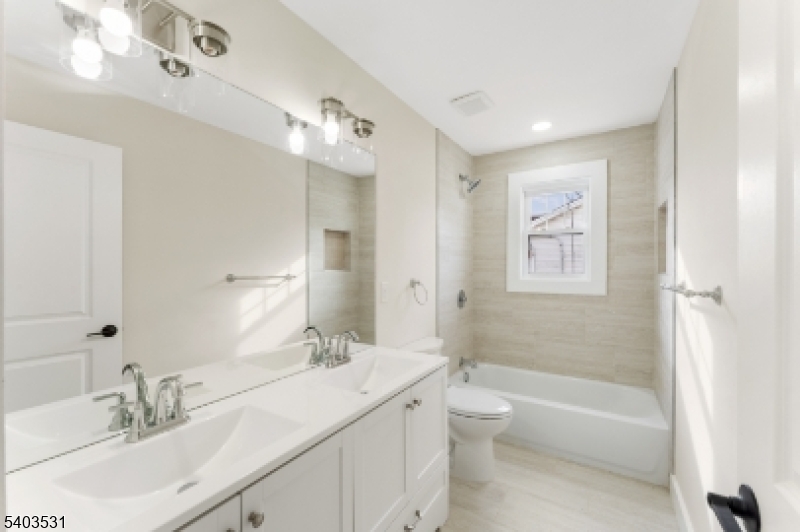 306 Carnegie Place Union, NJ 07088 - Photo 13 of 23 a bathroom with a double vanity sink toilet mirror and bathtub