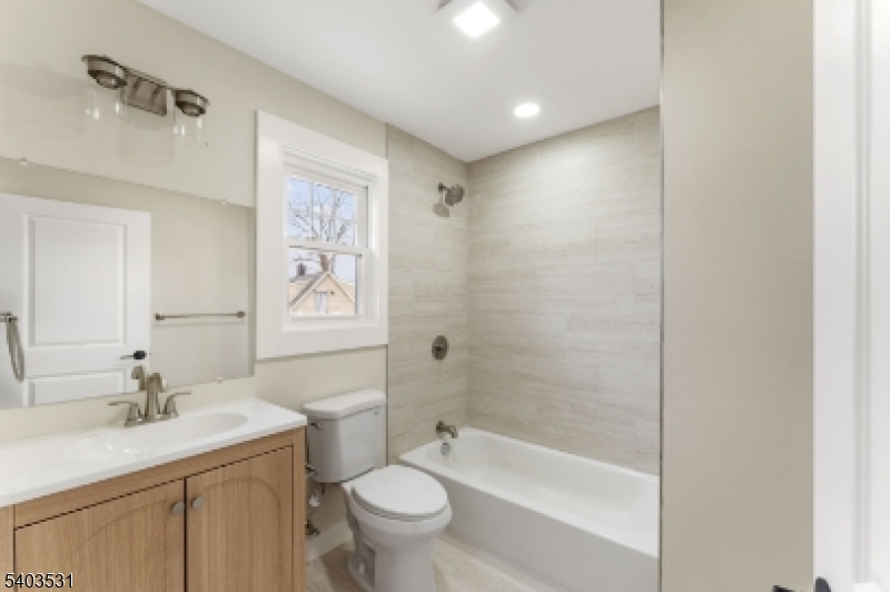 306 Carnegie Place Union, NJ 07088 - Photo 15 of 23 a bathroom with a bathtub shower sink vanity mirror and toilet
