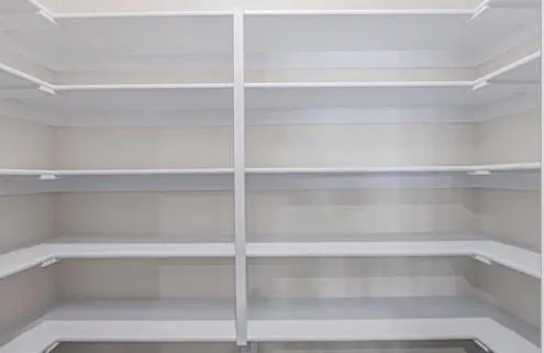 a view of walk in closet with empty racks