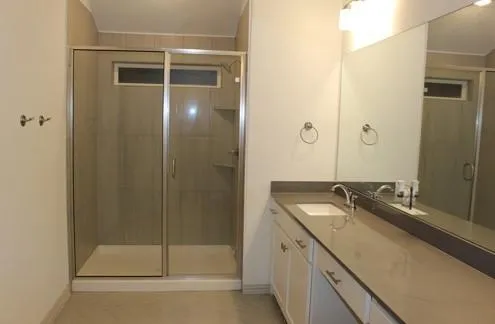 a bathroom with a granite countertop sink a mirror and shower