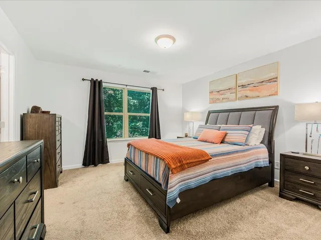 a bed sitting in a bedroom next to a window