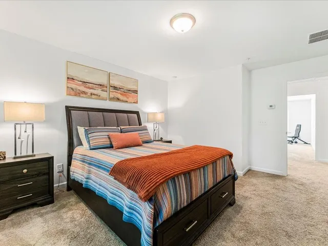 a bedroom with a bed and a night stand