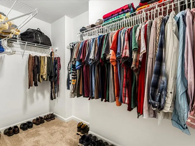 a view of walk in closet with clothes and shoes