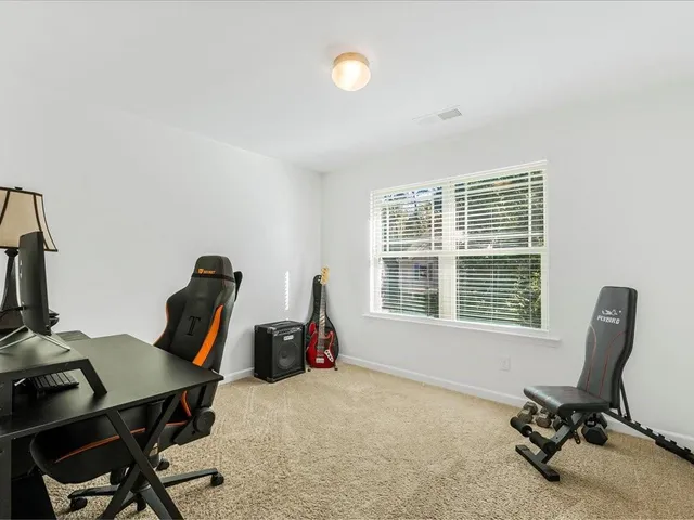 a view of a workspace with furniture and a window