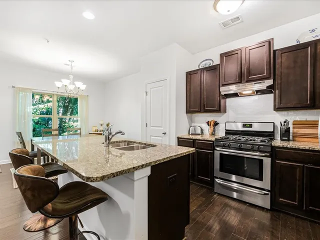 a kitchen with stainless steel appliances granite countertop a stove and a sink