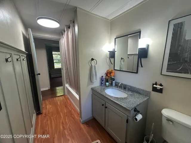 a bathroom with a granite countertop sink toilet and mirror