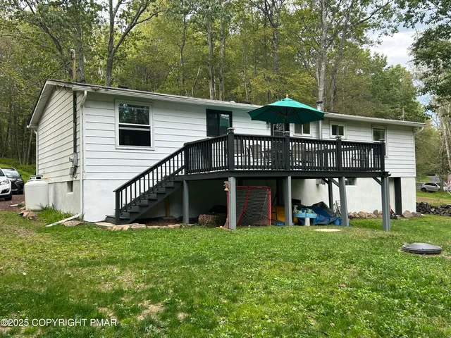 a view of a house with a yard and a deck