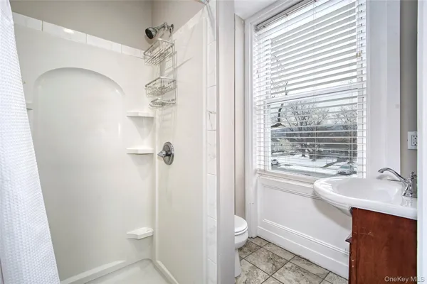 a bathroom with a sink a toilet and shower