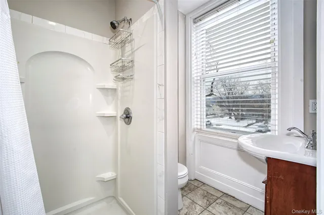 a bathroom with a sink a toilet and shower