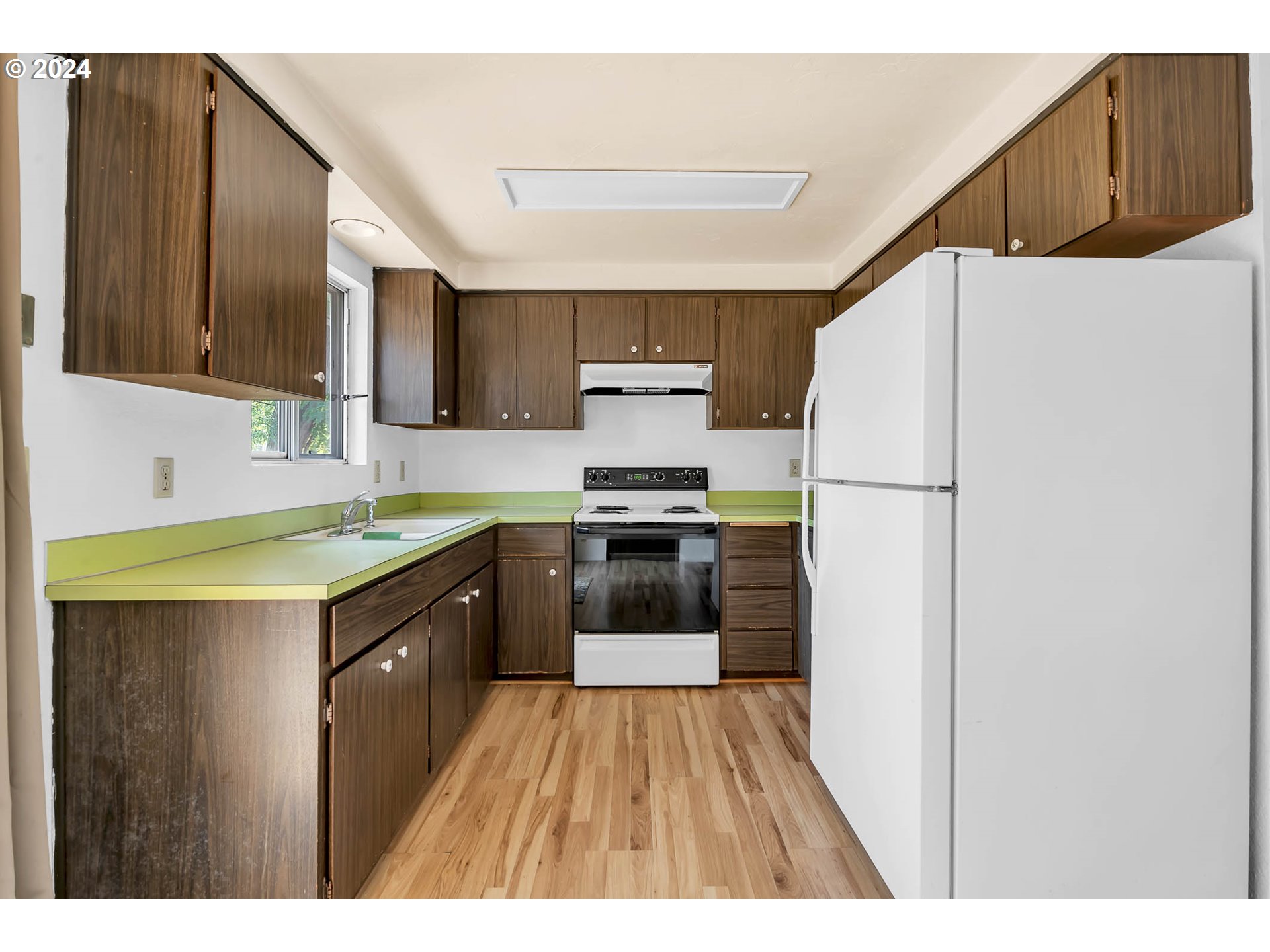 6112 Main Street Springfield, OR 97478 - Photo 30 of 47 a kitchen with a refrigerator a stove top oven a sink and dishwasher with wooden floor