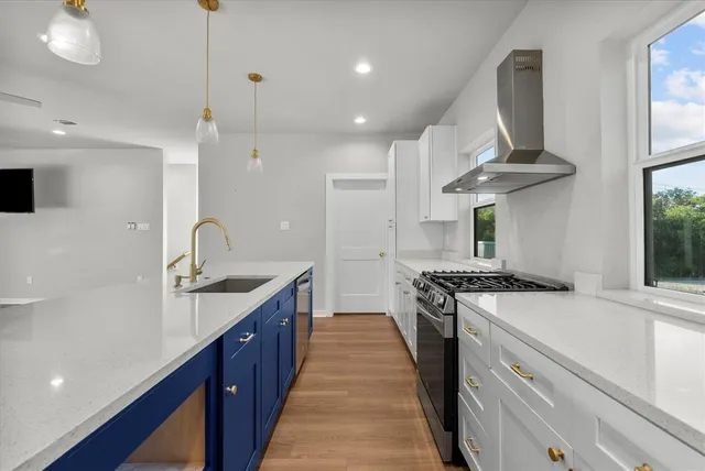 a kitchen with stainless steel appliances granite countertop a sink a stove and a refrigerator