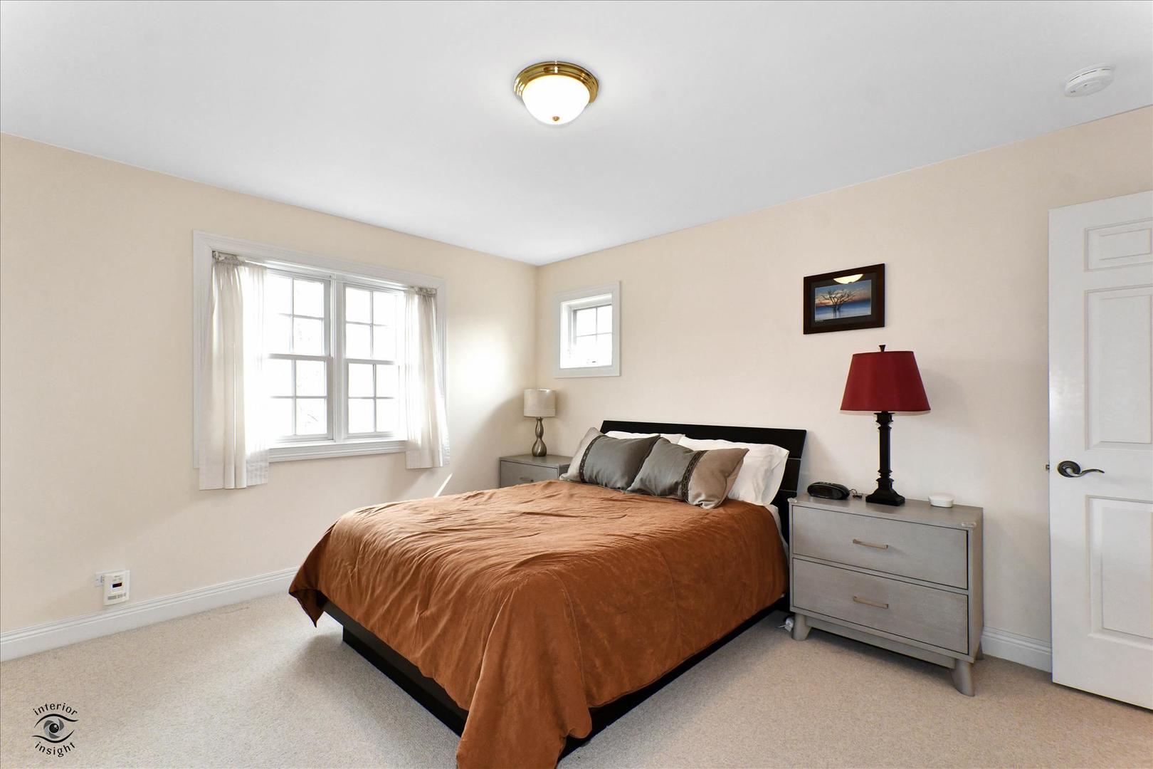 617 Hillside Road Glenview, IL 60025 - Photo 31 of 46 a bedroom with a bed and a lamp