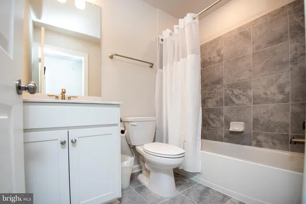 a bathroom with a sink a toilet a mirror and shower