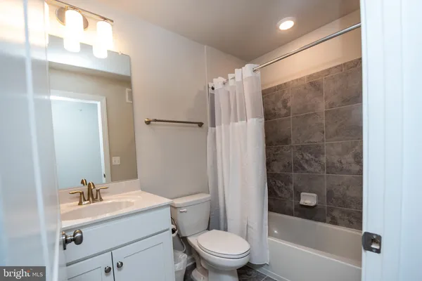 a bathroom with a sink mirror toilet and shower