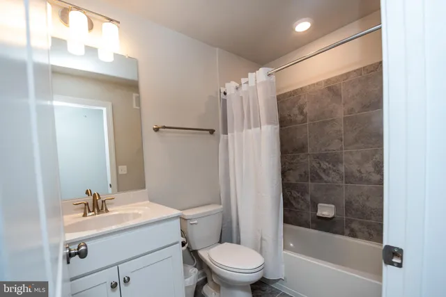 a bathroom with a sink mirror toilet and shower