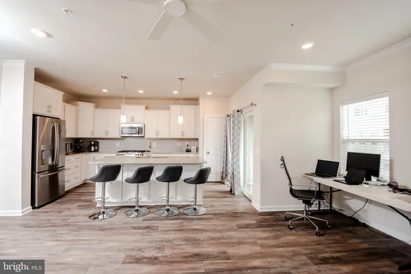 a view of kitchen with wooden floor and chairs