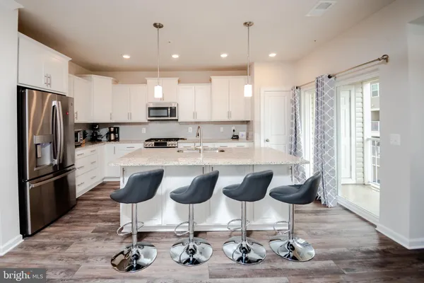 a kitchen with granite countertop a sink cabinets and stainless steel appliances