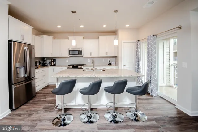 a kitchen with granite countertop a sink cabinets and stainless steel appliances