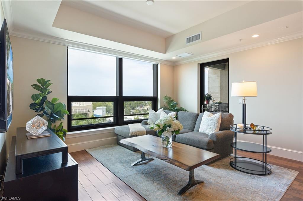 9115 Strada Place, Unit 5506 Naples, FL 34108 - Photo 20 of 46 Living room featuring ornamental molding, wood finished floors, and a tray ceiling