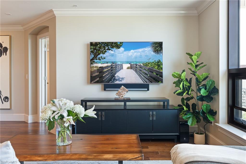 9115 Strada Place, Unit 5506 Naples, FL 34108 - Photo 23 of 46 Living area featuring crown molding, wood finished floors, and arched walkways