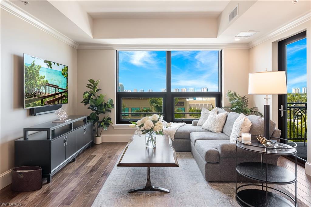 9115 Strada Place, Unit 5506 Naples, FL 34108 - Photo 3 of 46 Living area with Lots of natural light & wood finished floors