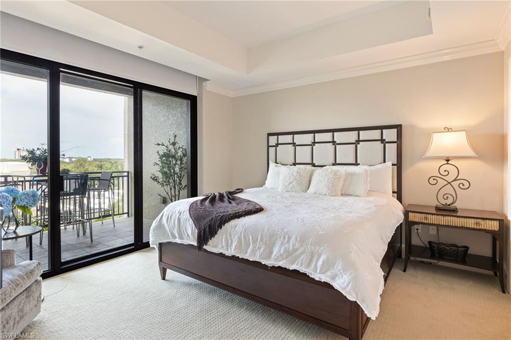 9115 Strada Place, Unit 5506 Naples, FL 34108 - Photo 10 of 46 Carpeted bedroom with access to exterior, ornamental molding, and a tray ceiling