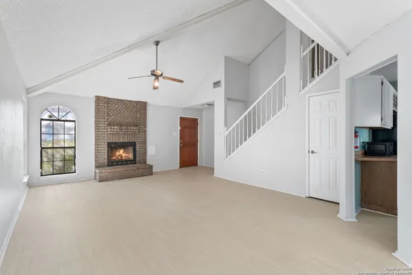 a view of an empty room with fireplace and a window