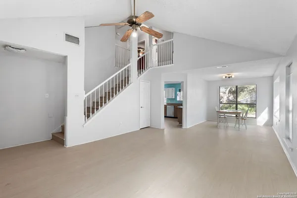 a view of a livingroom with wooden floor and a ceiling fan