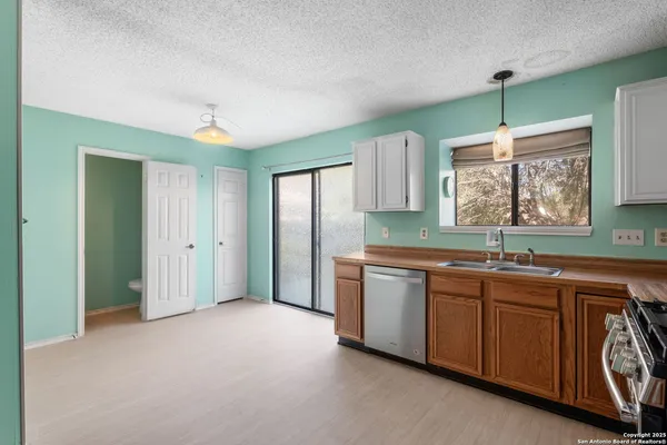 a kitchen with stainless steel appliances granite countertop a sink and a refrigerator