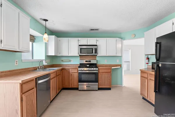 a kitchen with stainless steel appliances granite countertop a stove a sink and a refrigerator