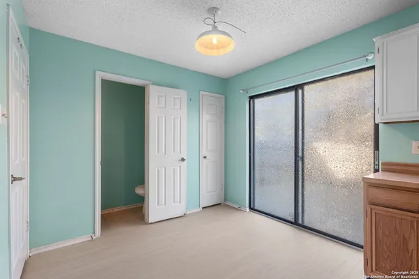 a view of an empty room with window and bathroom