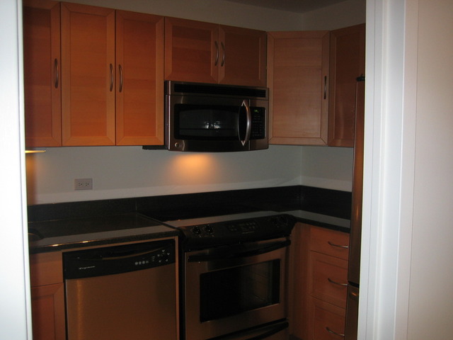 5415 North Sheridan Road, Unit 1715 Chicago, IL 60640 - Photo 16 of 24 a kitchen with wooden cabinets and a stove top oven
