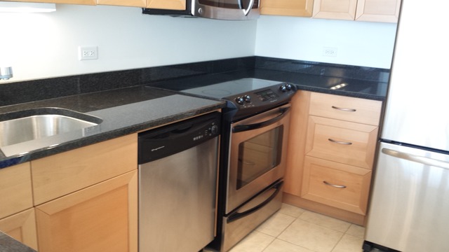 5415 North Sheridan Road, Unit 1715 Chicago, IL 60640 - Photo 7 of 24 a kitchen with granite countertop white cabinets and white appliances