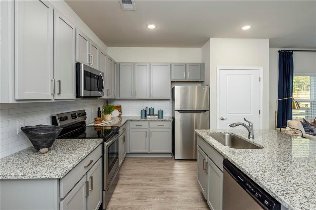 100 Cottage Way, Unit NUTMEG Hampton, GA 30228 - Photo 15 of 44 a kitchen with a sink stove and refrigerator