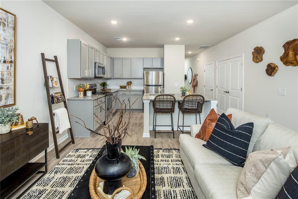 100 Cottage Way, Unit NUTMEG Hampton, GA 30228 - Photo 16 of 44 a living room with furniture a rug and a chandelier