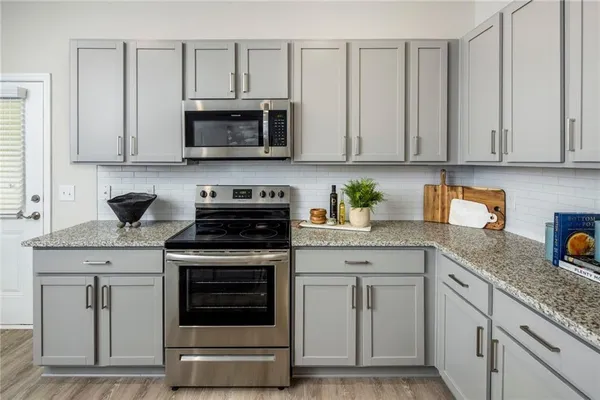 a kitchen with stainless steel appliances granite countertop a stove a microwave and cabinets
