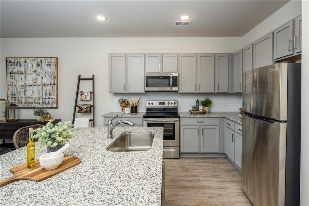 100 Cottage Way, Unit NUTMEG Hampton, GA 30228 - Photo 31 of 44 a kitchen with a refrigerator sink and stove