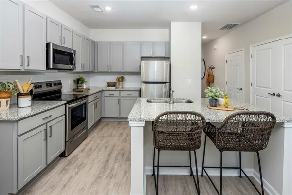 a kitchen with a table chairs microwave and cabinets