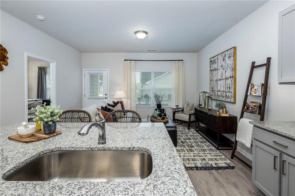 100 Cottage Way, Unit NUTMEG Hampton, GA 30228 - Photo 37 of 44 a kitchen with a sink a stove and a wooden floor