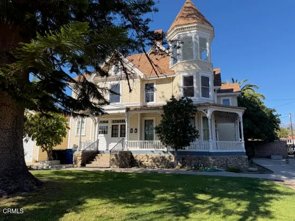 a front view of a house with a garden and trees