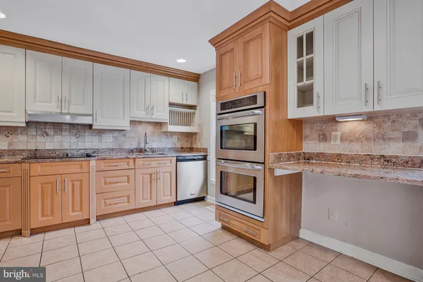 a kitchen with a refrigerator sink and cabinets