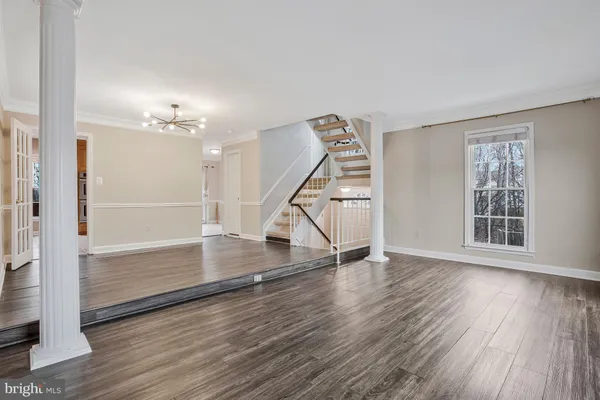 an empty room with wooden floor and staircase