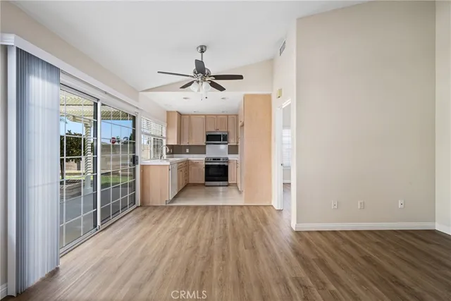 a view of a kitchen with wooden floor and stainless steel appliances