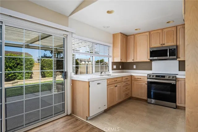 a kitchen with stainless steel appliances granite countertop a stove a sink and a microwave