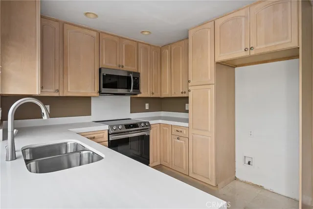 a kitchen with granite countertop a sink a stove and cabinets