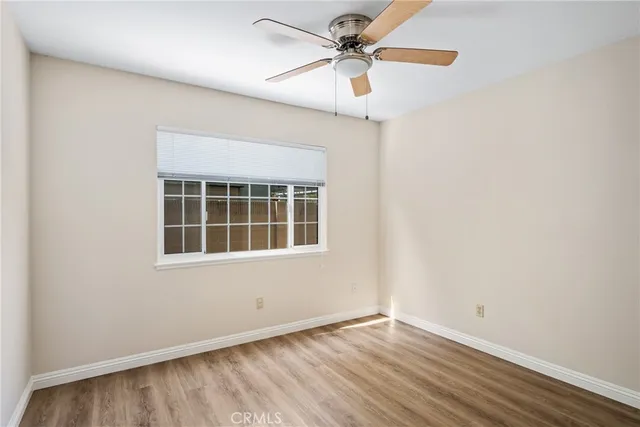 an empty room with a window and a fan