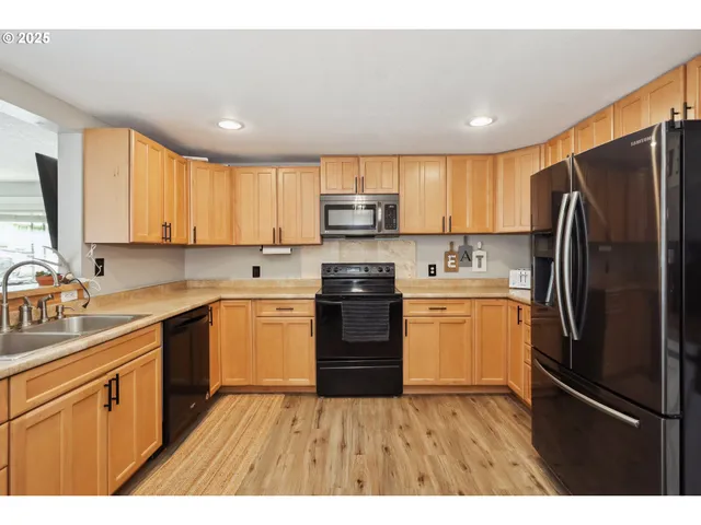 a kitchen with a refrigerator sink and wooden cabinets