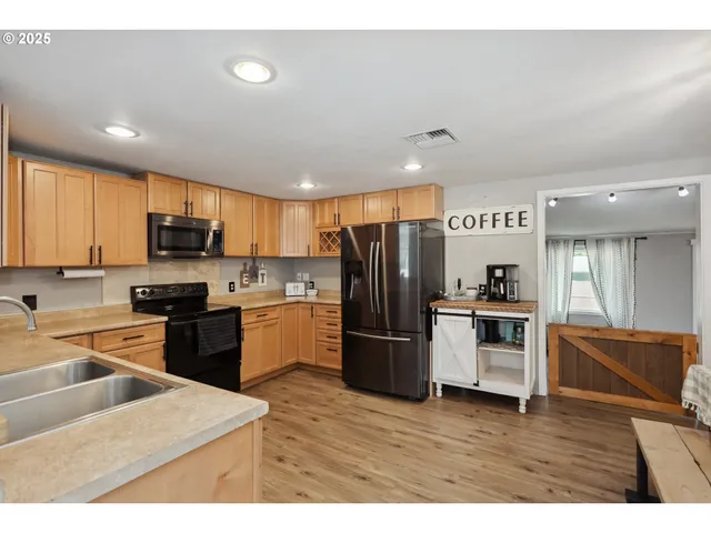 a kitchen with refrigerator cabinets and wooden floor