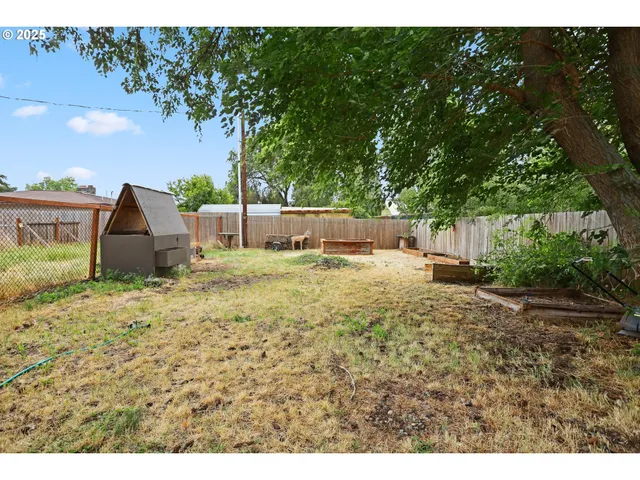a backyard of a house with table and chairs